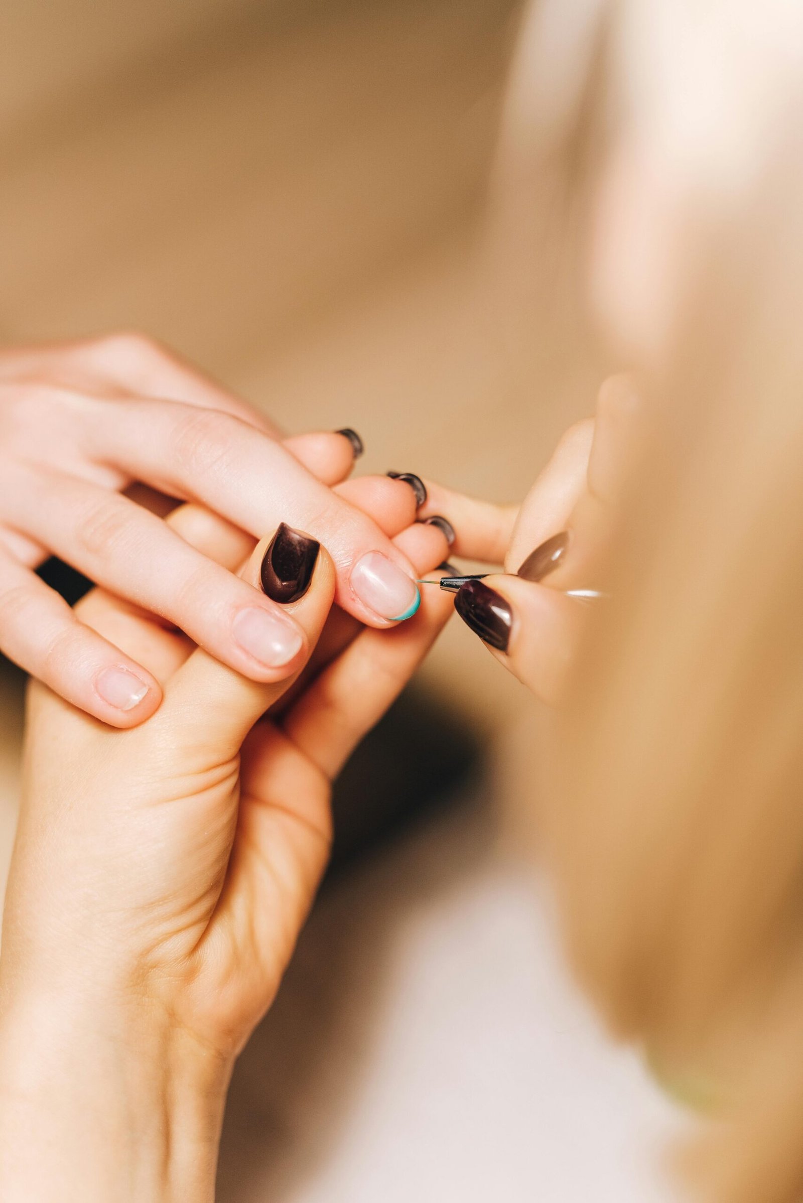 Esthéticienne en train de poser des capsules sur les ongles d'une cliente lors d'une séance de manucure en institut