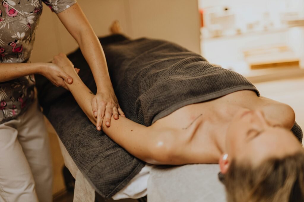 A serene spa setting with a woman receiving an arm massage, promoting relaxation and wellness.